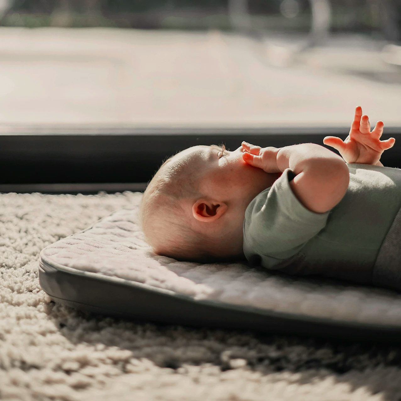 Baby on a mattress on the floor awake